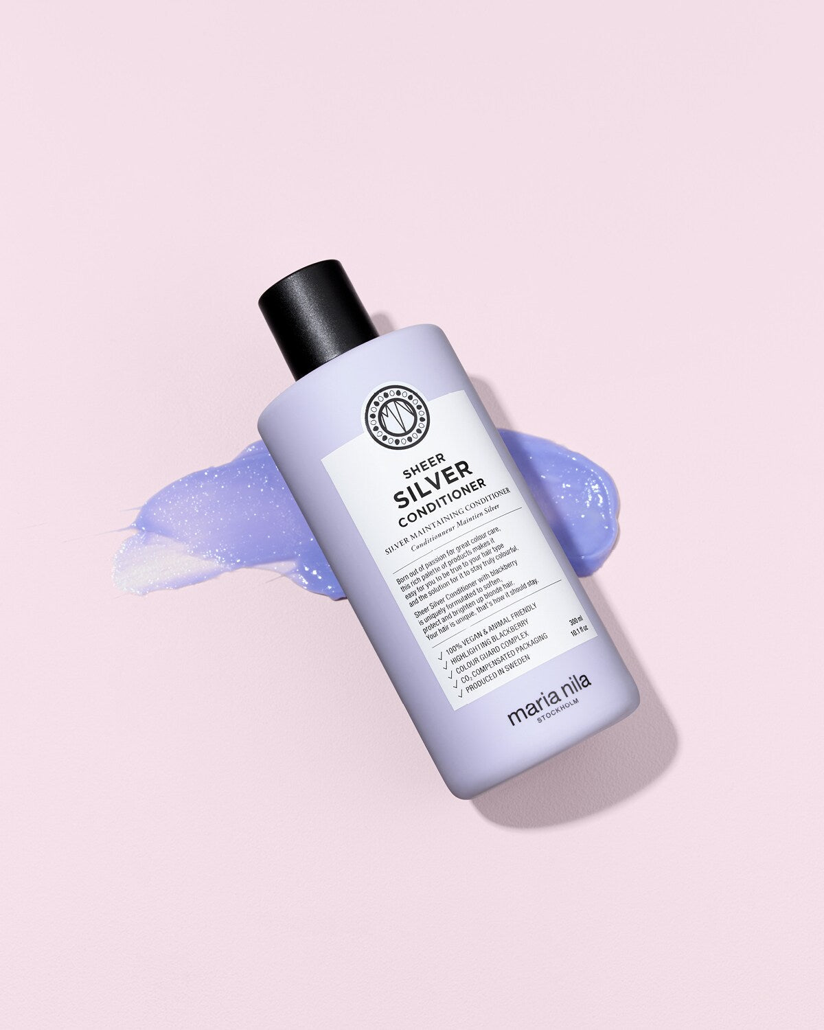 Maria Nila Sheer Silver Conditioner 300 ml geopende fles met paarse textuur
